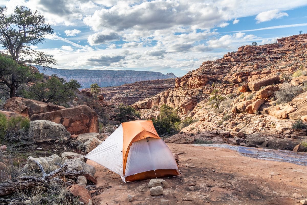 tent in a desert landscape by a stream